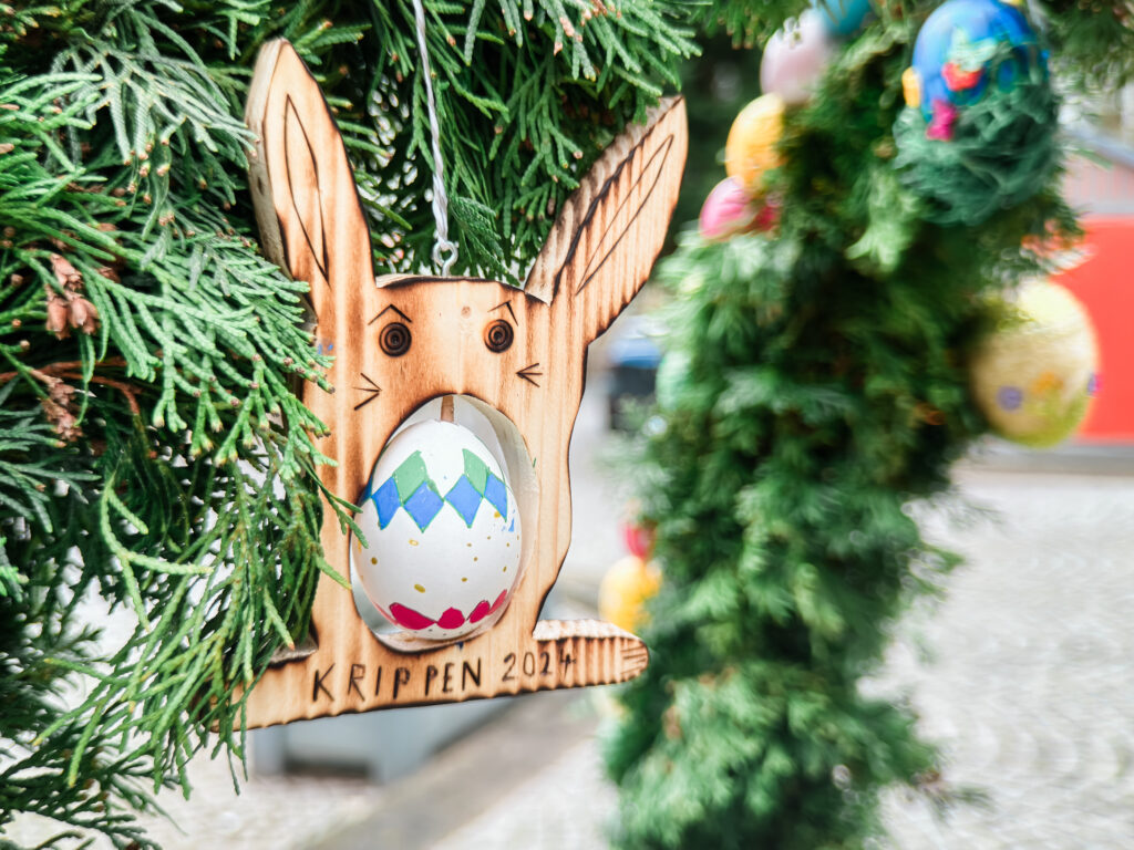 Bemaltes Osterei eingearbeitet in einem Holzhasen beim Osterbrunnenfest in Krippen